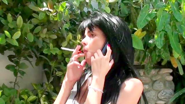 Dark-haired babe is smoking a cigarette