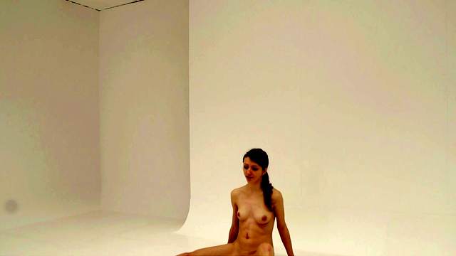 Brunette teen dressed in jeans poses naked on the floor