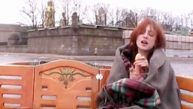 Redhead model is sucking her dildo outdoors