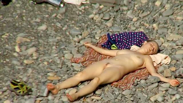 Pretty slender cutie is getting naked on the beach