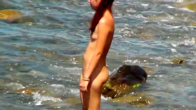 Slender tanned babe is lying on the beach