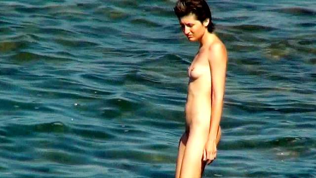 Tall brunette poses naked in the sea