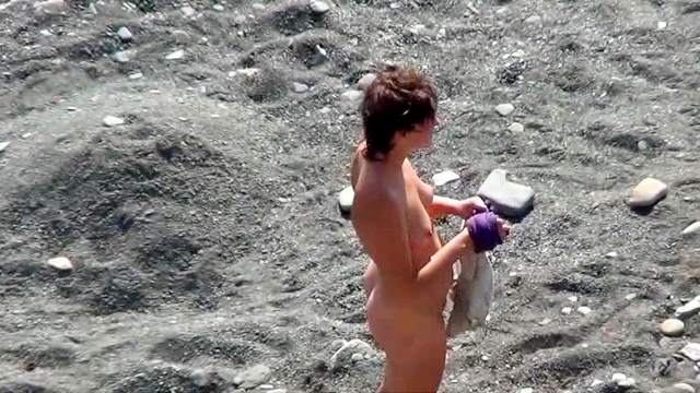 Sexy nudist is getting naked on the beach