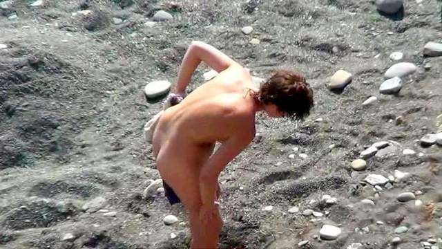 Sexy nudist is getting naked on the beach