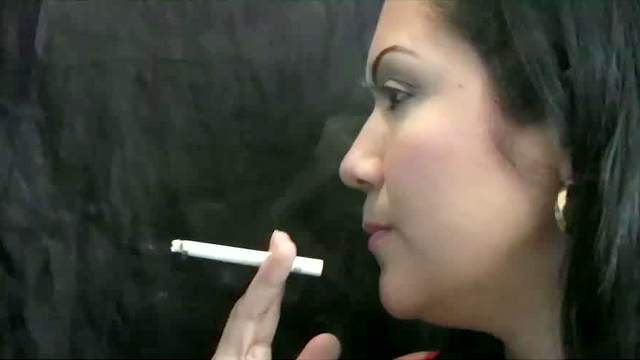 Latina blowing smoke sensually