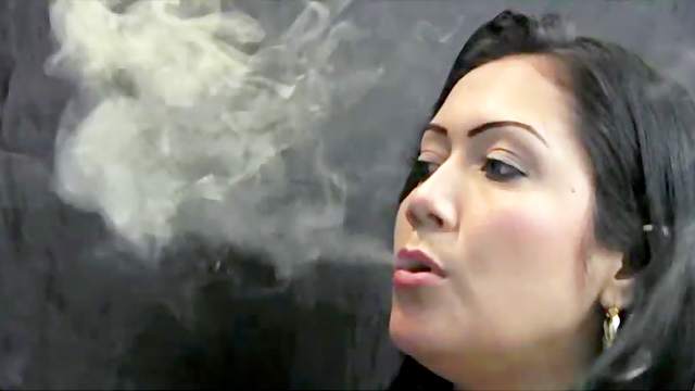 Latina blowing smoke sensually