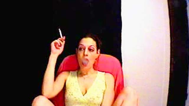 Attractive lady smokes a cigarette in front of her webcam