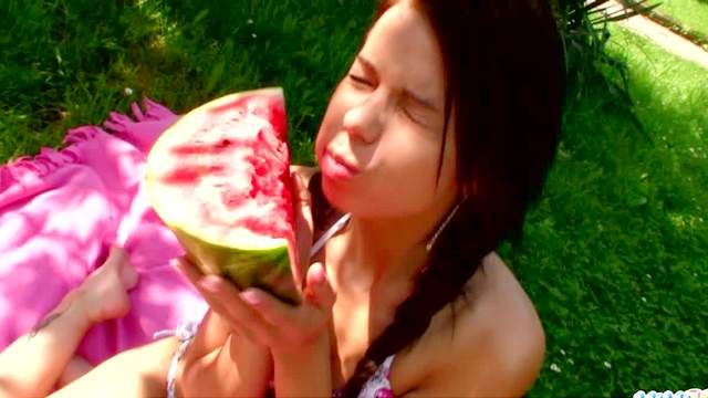 Ambrosial and ravishing doll is eating watermelon outdoors