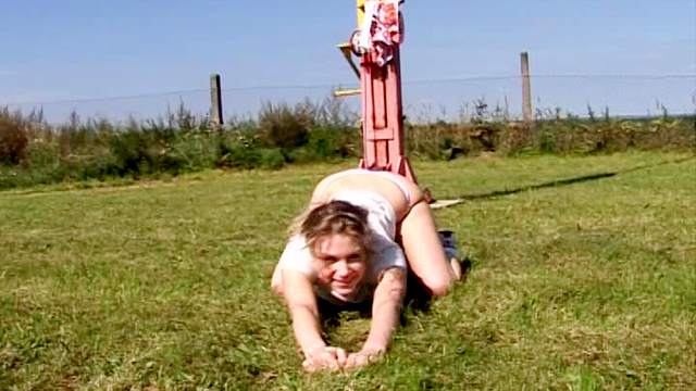 Sporty girl fucks dildo in a field