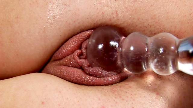 Glass dildo penetrates a sexy teen pussy