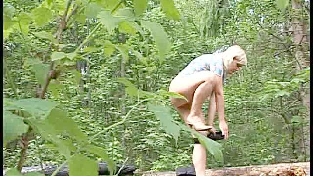 Pissing blonde girl sits on a log