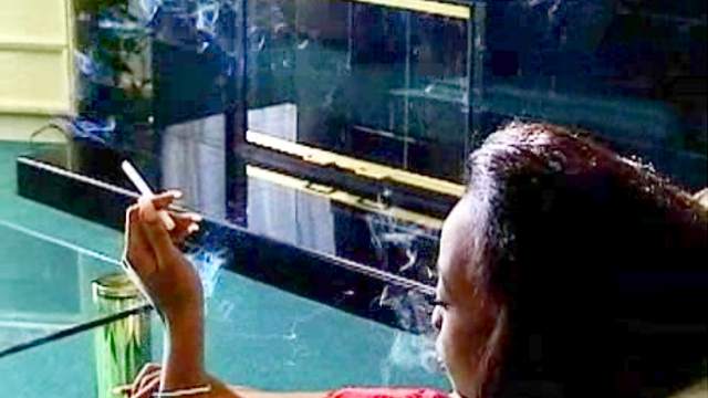 Black girl smokes cigarette solo