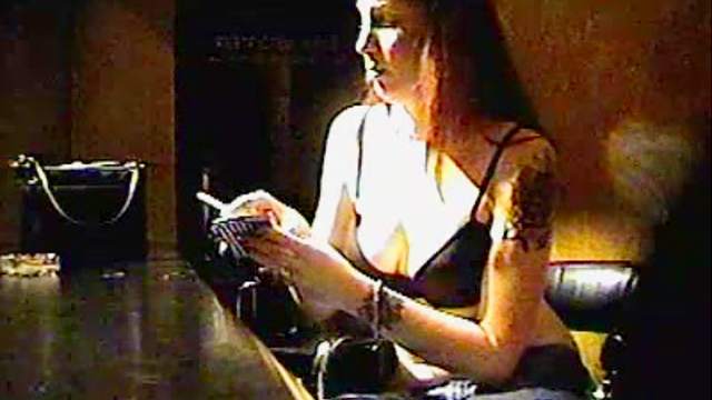Chick in jeans smokes a cigarette