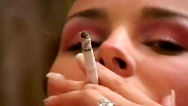 Slender teen with cute face smoking in a sexy way