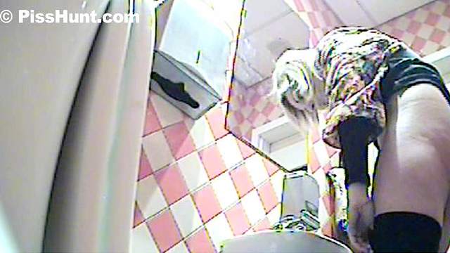 Sexy blonde is pissing in the toilet