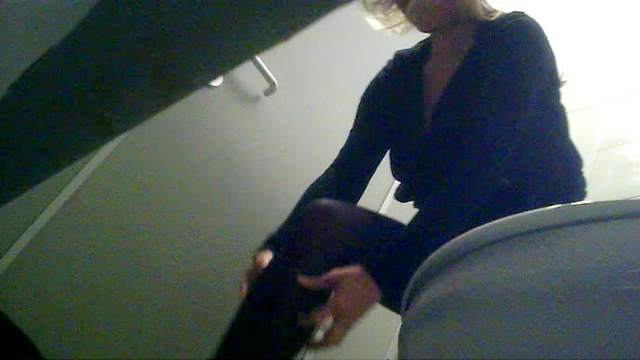 Seductive blonde is pissing in the toilet