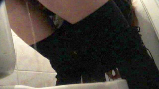 Cute busty babe is peeing in the public toilet