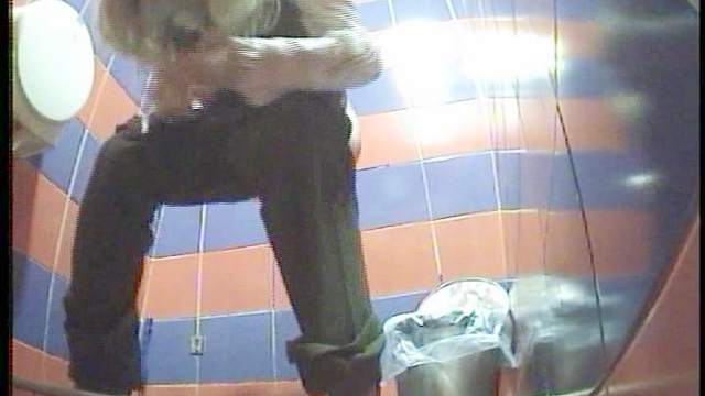 Slender blonde is pissing in the cute toilet