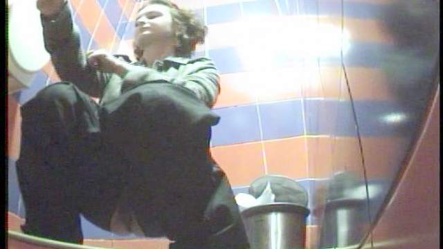 Nasty curly brunette is peeing in a sexy toilet
