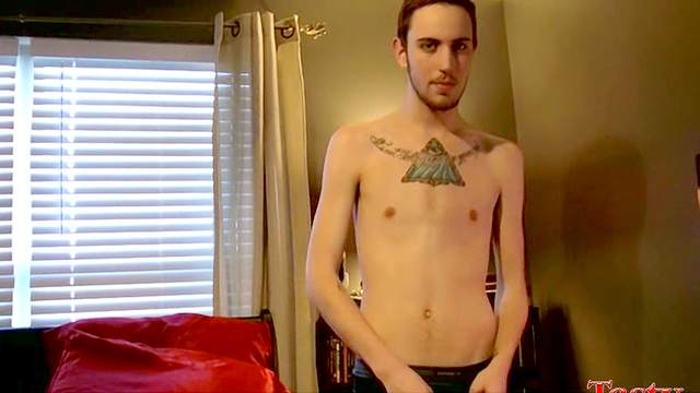 Tattooed gay is playing with his hard dick in the bedroom