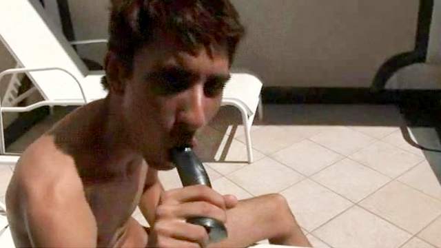 Skinny dude is lying and sucking his dildo